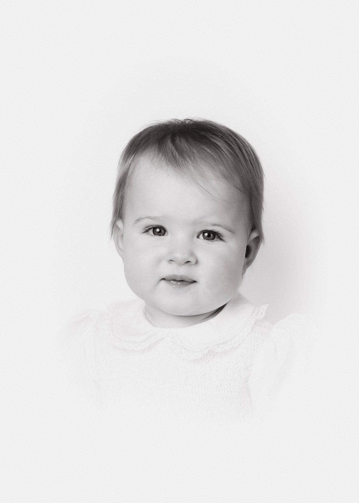 Heirloom portrait — a young girl in a smocked white dress